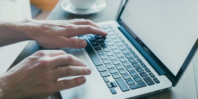 Mensch tippt auf Computertastatur.