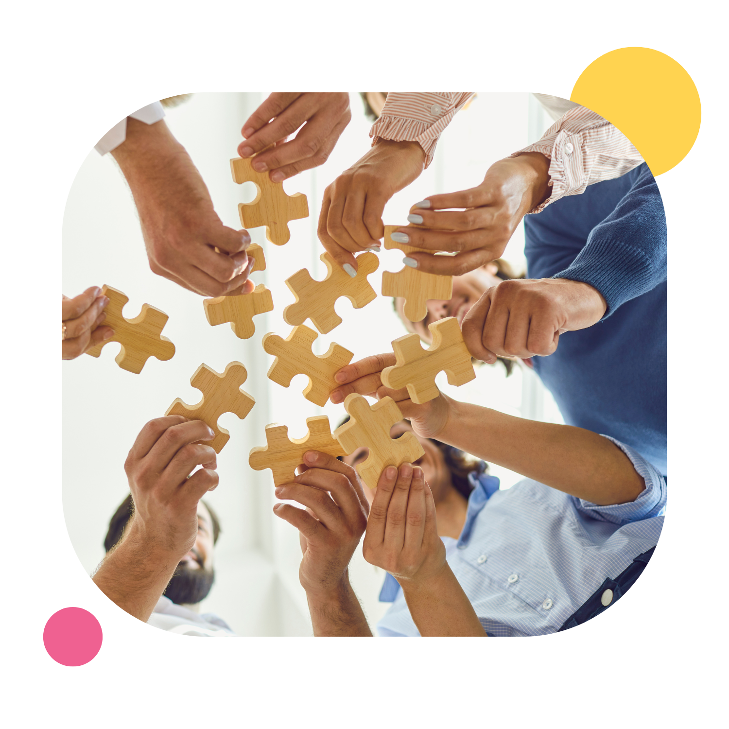Eine Gruppe Menschen mit Puzzleteilen in den Händen als Symbol für Teamarbeit.